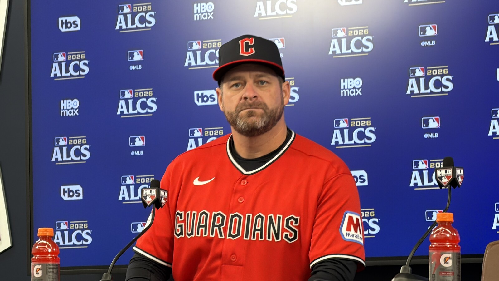 Guardians manager Stephen Vogt at a press conference in front of a 2026 ALCS backdrop
