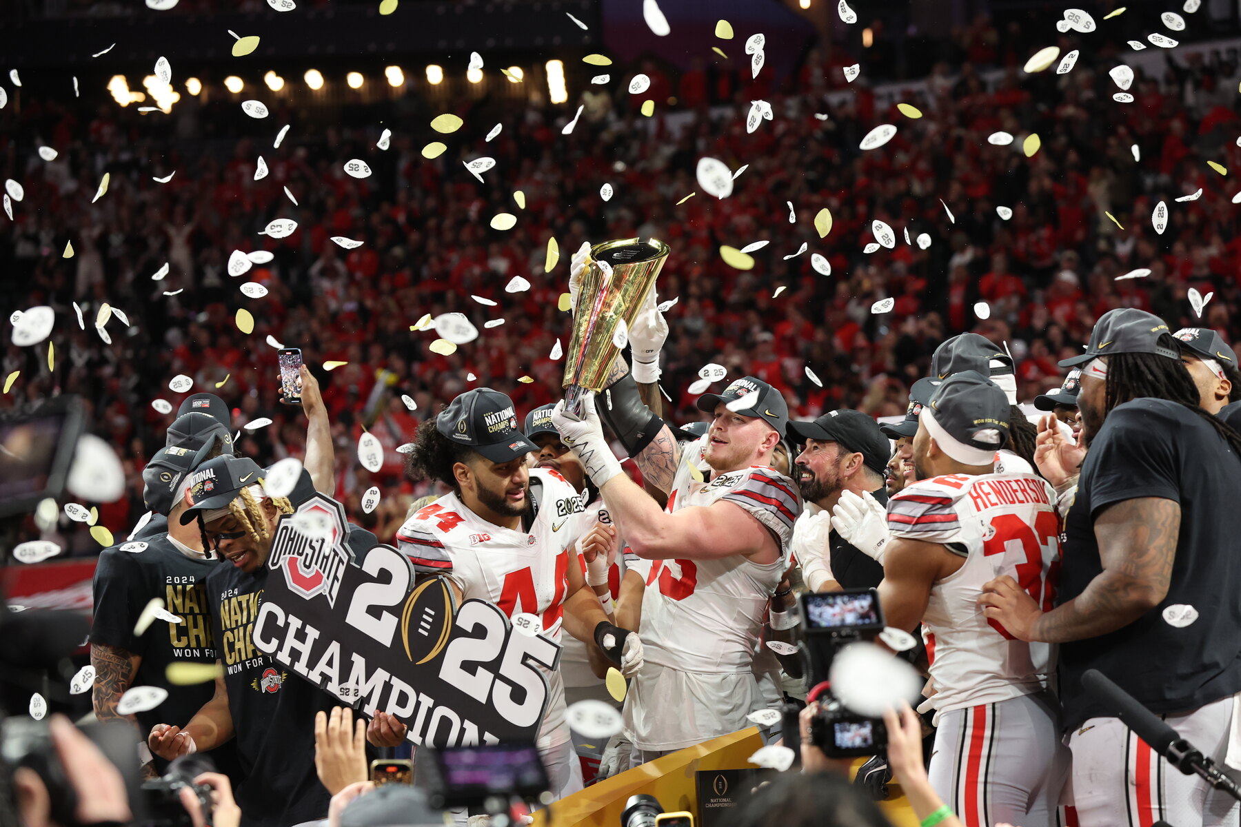 Jack Sawyer holding the national championship trophy amid confetti after Ohio State won the 2025 title