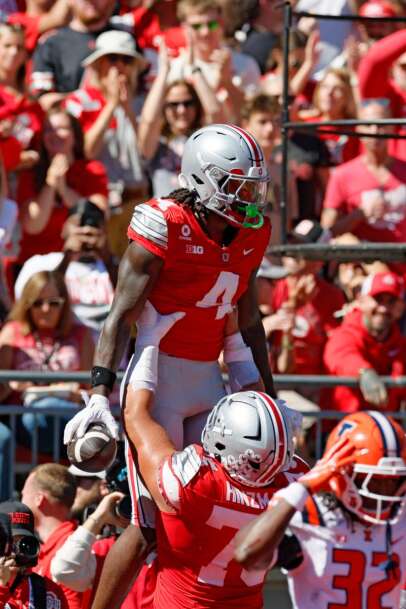 Ohio State receiver Jeremiah Smith is lifted by lineman Carson Hinzman while celebrating a touchdown against Illinois