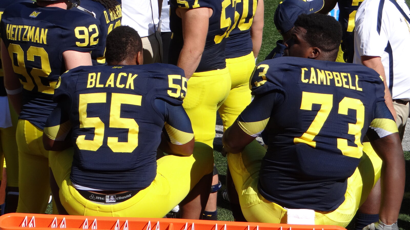 Michigan defensive tackles Jibreel Black and Will Campbell seated together on the bench during a game