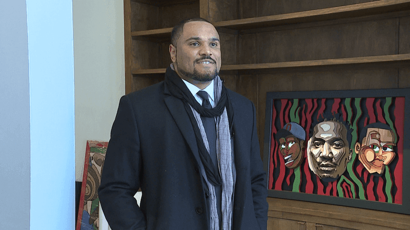 Percy King standing beside his artwork in an ABC6 profile